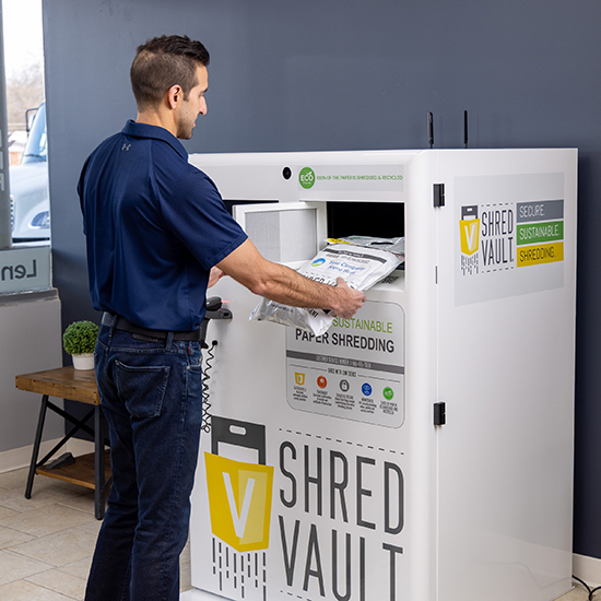 Shred bag being dropped into a Shred Vault Kiosk