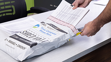 Documents being put into a Shred Vault Shred Bag